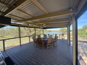 a patio with a table and chairs on a deck at Lake Bywater Cottage in Walker Flat