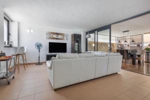 a living room with a white couch and a tv at Carmina House in Costa Calma