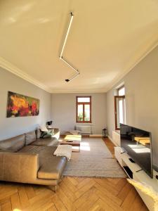 a living room with a couch and a flat screen tv at Ferienwohnung am Schlossplatz in Wolfegg
