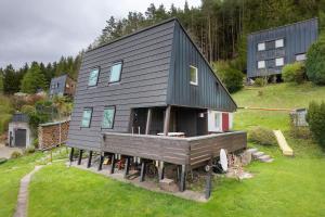 a black house with a deck on a yard at Urlaub Im Häusle in Loßburg