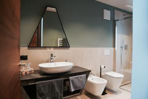 a bathroom with a sink and a toilet and a mirror at Aktiv Lodge Meran - Terrace Two in San Martino +30 photos