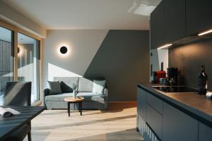 a kitchen and living room with a couch at Aktiv Lodge Meran - Terrace Two in San Martino