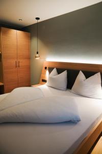 a large bed with white sheets and pillows at Aktiv Lodge Meran - Terrace Two in San Martino