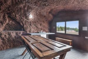 a dining room with a wooden table and a window at Casa Efrén in Garafía