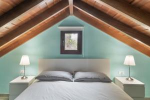 a bedroom with blue walls and a bed with two lamps at Casa Efrén in Garafía