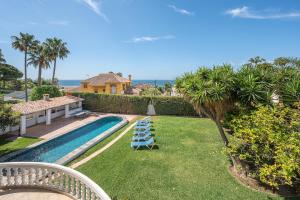 a backyard with a swimming pool with lounge chairs at Marbella Villa 16 Persons -Pool in Marbella