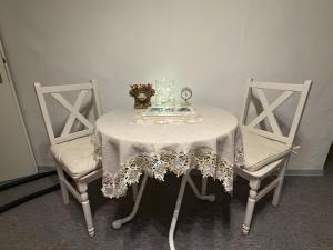 a table with two chairs and a table with a white table cloth at Ferienwohnung Silbergarten in Clausthal-Zellerfeld +25 photos