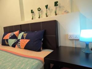 una camera con letto, scrivania e cuscini di The Pillohouzzze a Malacca
