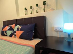 a bedroom with a bed with a desk and pillows at The Pillohouzzze in Melaka