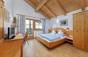 a bedroom with a bed and a desk and a television at Humblhof in Lagundo