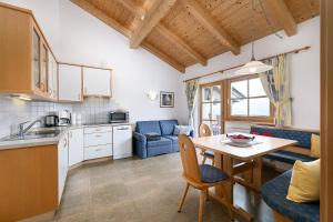 a kitchen and living room with a table and chairs at Humblhof in Lagundo