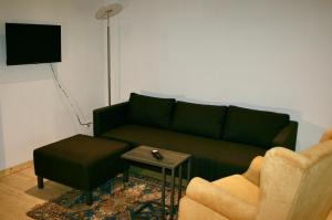 a living room with a green couch and a table at Villa Buselmeier in Neuried