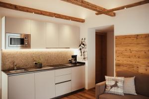 a kitchen with white cabinets and a counter top at Chalet La Flüta Viola in La Valle
