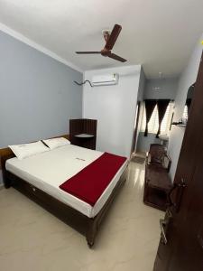 a bedroom with a bed and a ceiling fan at Velan view in Palni