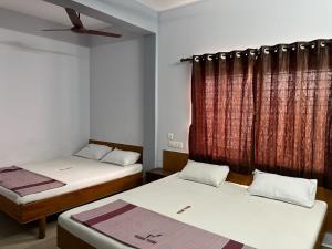 a room with two beds and a window at Velan view in Palni