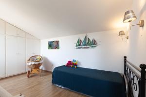 a bedroom with a blue bed and a chair at Villa L'Acanthe in Six-Fours-les-Plages +20 photos