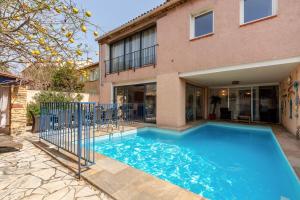 a swimming pool in front of a house at Villa L'Acanthe in Six-Fours-les-Plages