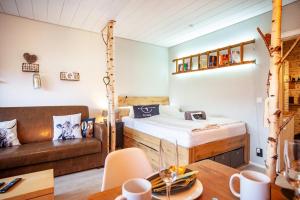 ein Zimmer mit einem Bett, einer Couch und einem Tisch in der Unterkunft Q-stadl in Steibis