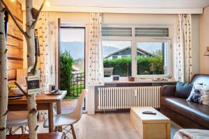 ein Wohnzimmer mit Sofa und großem Fenster in der Unterkunft Q-stadl in Steibis