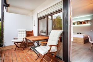ein Esszimmer mit einem Tisch und weißen Stühlen in der Unterkunft Q-stadl in Steibis