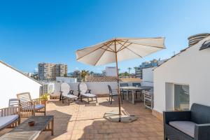a patio with a table and an umbrella on a roof at Can Marineta in Palma de Mallorca