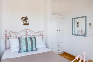 a bedroom with a bed with white sheets and pillows at Luna Rossa Milos - Moon Kiss in Provatas +21 photos