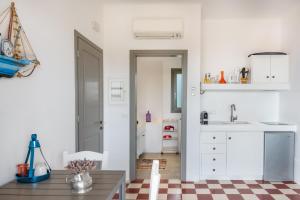 a kitchen with white cabinets and a checkered floor at Luna Rossa Milos - Moon Kiss in Provatas