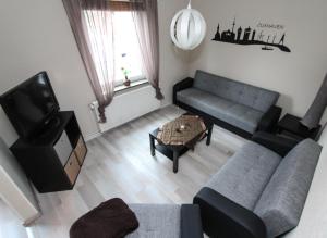 a living room with a couch and a tv at Ferienhaus Olenbrook in Cuxhaven