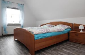 a bedroom with a bed with a wooden frame and a window at Ferienhaus Olenbrook in Cuxhaven