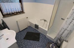 a bathroom with a tub and a toilet and a sink at Ferienhaus Olenbrook in Cuxhaven +7 photos