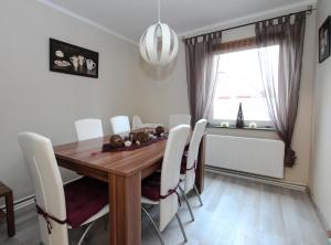 a dining room with a wooden table and white chairs at Ferienhaus Olenbrook in Cuxhaven