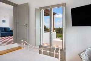 a room with a bed and a sliding glass door at Luna Rossa Milos - Moon Kiss in Provatas