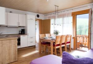 a kitchen and dining room with a table and chairs at Geigerbauernhof in Mühlenbach