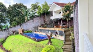 a man standing in front of a house with a swimming pool at Villa Kay Height in Kopo 2