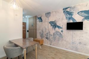 a dining room with a table and a tv on a wall at Appartamento Palau Alba in Palau