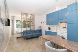 a kitchen with blue cabinets and a wooden table at Appartamento Palau Alba in Palau