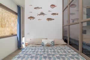 a bedroom with a bed with fish stickers on the wall at Appartamento Palau Alba in Palau