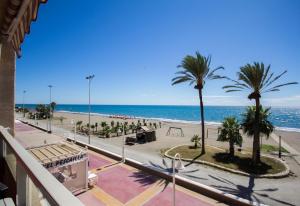 a view of a beach with palm trees and the ocean at Studio 2 Sea front in Rincón de la Victoria +17 photos