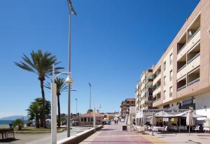 a street with a palm tree and a building at Studio 2 Sea front in Rincón de la Victoria