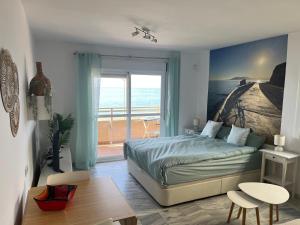 a bedroom with a bed with a view of the ocean at Studio 2 Sea front in Rincón de la Victoria