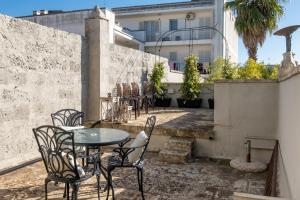 a patio with a table and chairs and a building at Maison Boutique At Daniela in San Pietro in Lama