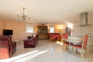 a kitchen and living room with a table and chairs at Villa Green in Saint-Amé
