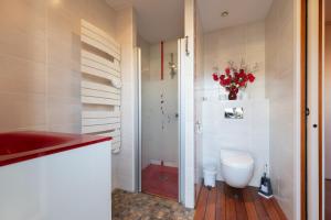 a bathroom with a toilet and a vase of flowers at Villa Green in Saint-Amé +17 photos