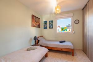 a bedroom with two beds and a window at Villa Green in Saint-Amé