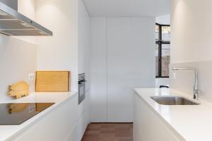 a kitchen with white countertops and a sink at Ganso golf in Benalmádena +18 photos