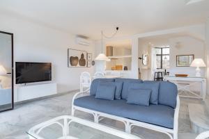 a living room with a blue couch and a tv at Ganso golf in Benalmádena