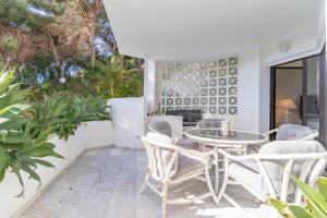 a patio with a table and chairs and plants at Ganso golf in Benalmádena
