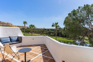 a balcony with a couch and a table and chairs at Ganso golf in Benalmádena