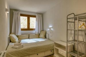 a small bedroom with a bed and a window at Apartamento en el centro in Begur