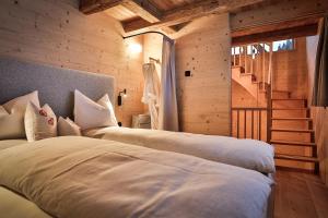 two beds in a room with a staircase at Burgfrieder Mühle in Rasun di Sopra